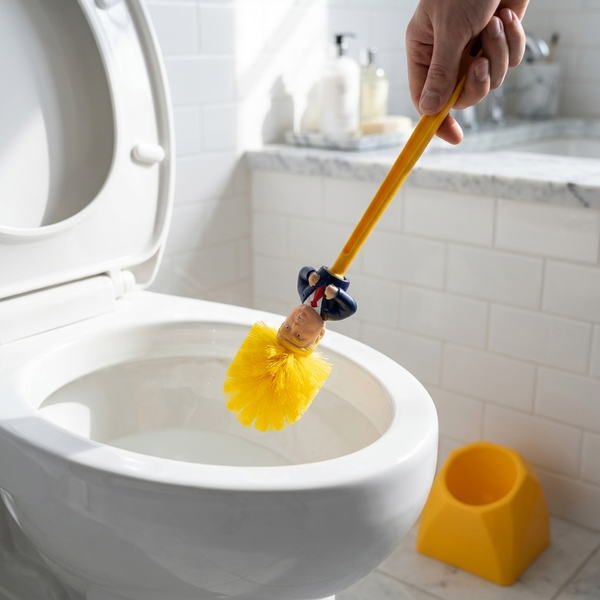 Brush being lowered head-first into a white toilet bowl